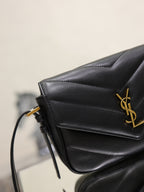 Black YSL bag close-up with gold logo on quilted front flap