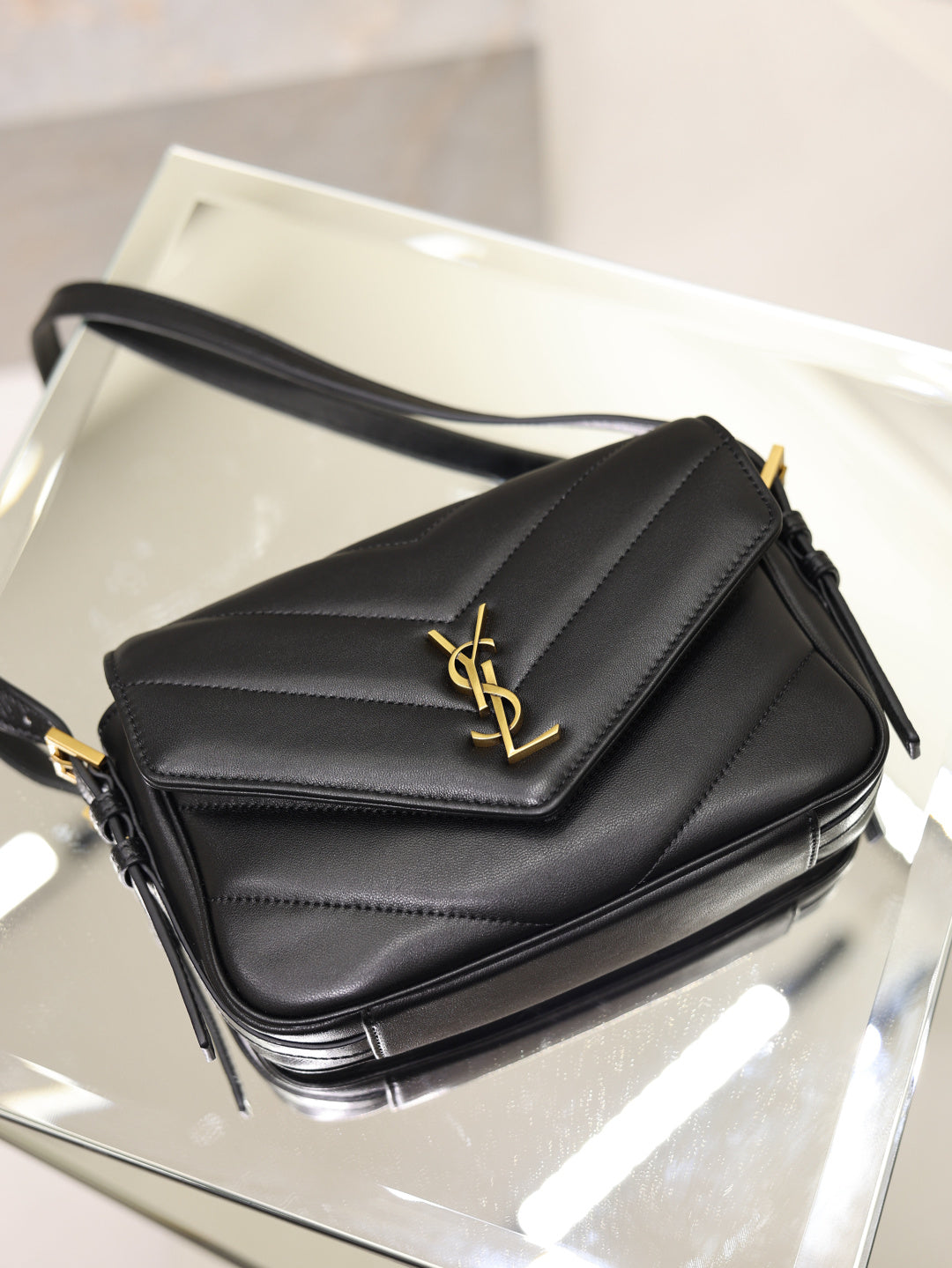 Black quilted YSL shoulder bag with gold logo on flap and adjustable strap