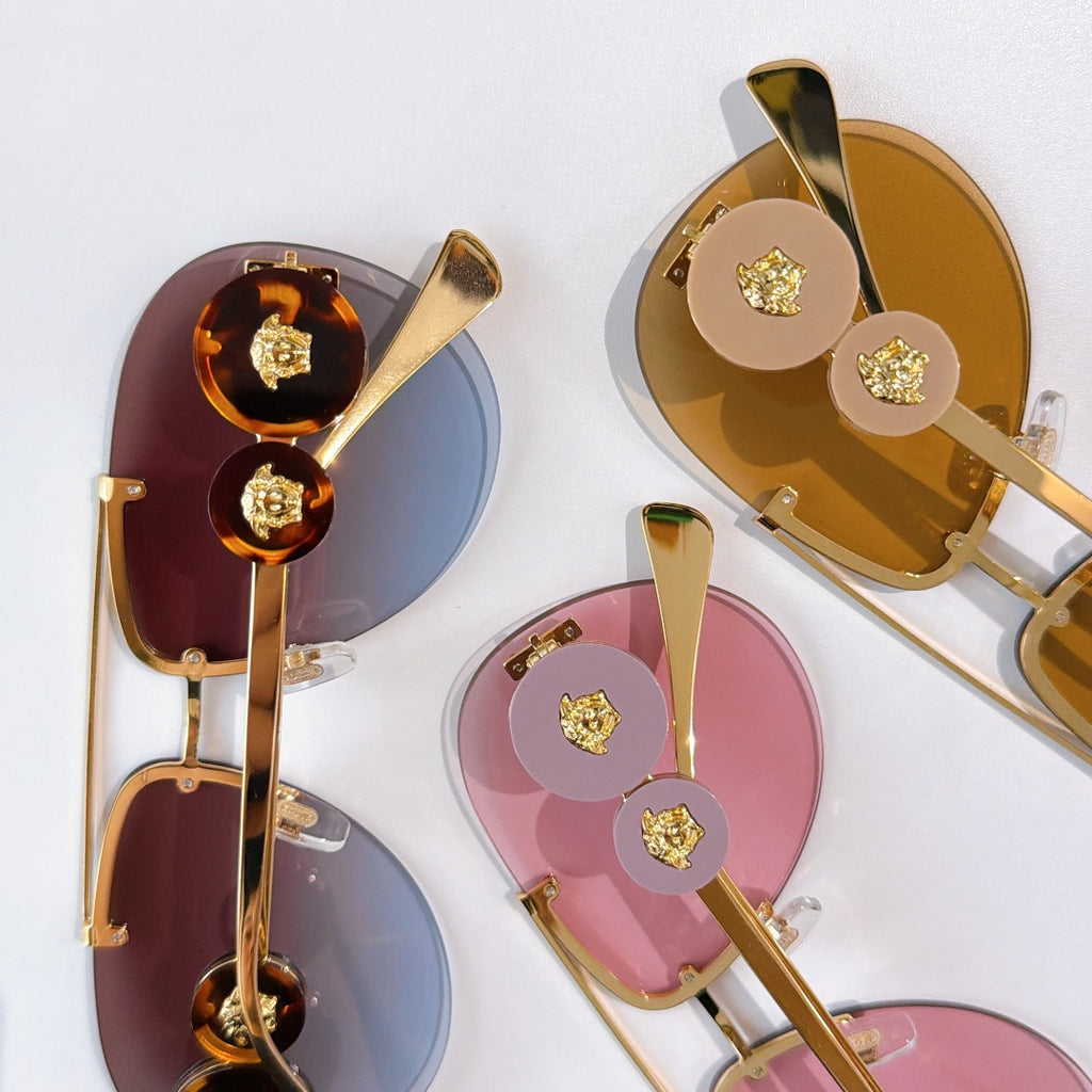 Gold-tone sunglasses with round emblem details and tinted mirrored lenses