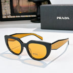 Prada sunglasses with black frame, orange lenses, and orange-tinted top trim