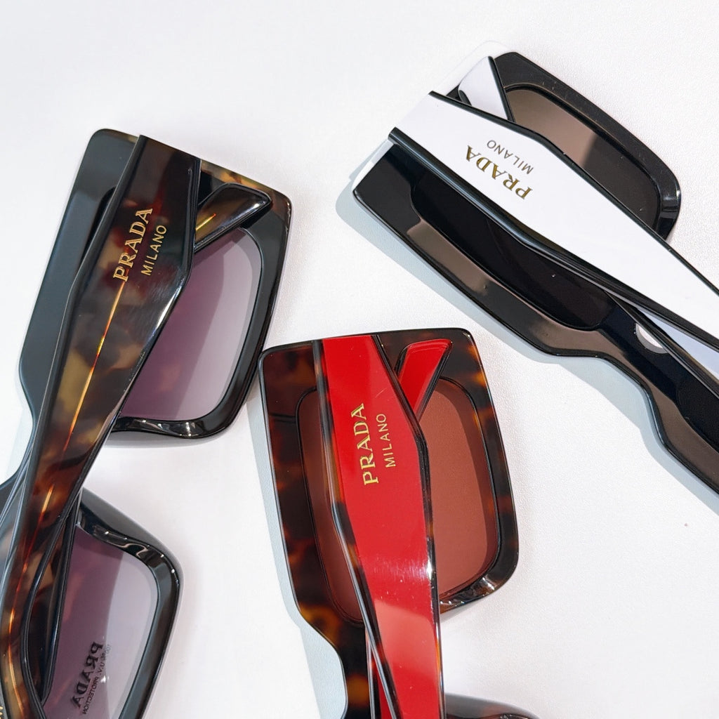 Prada sunglasses close-up: tortoiseshell and black frames with tinted lenses