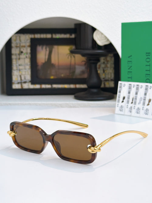 Glasses with dark brown lenses, tortoiseshell-look frames, and gold temples