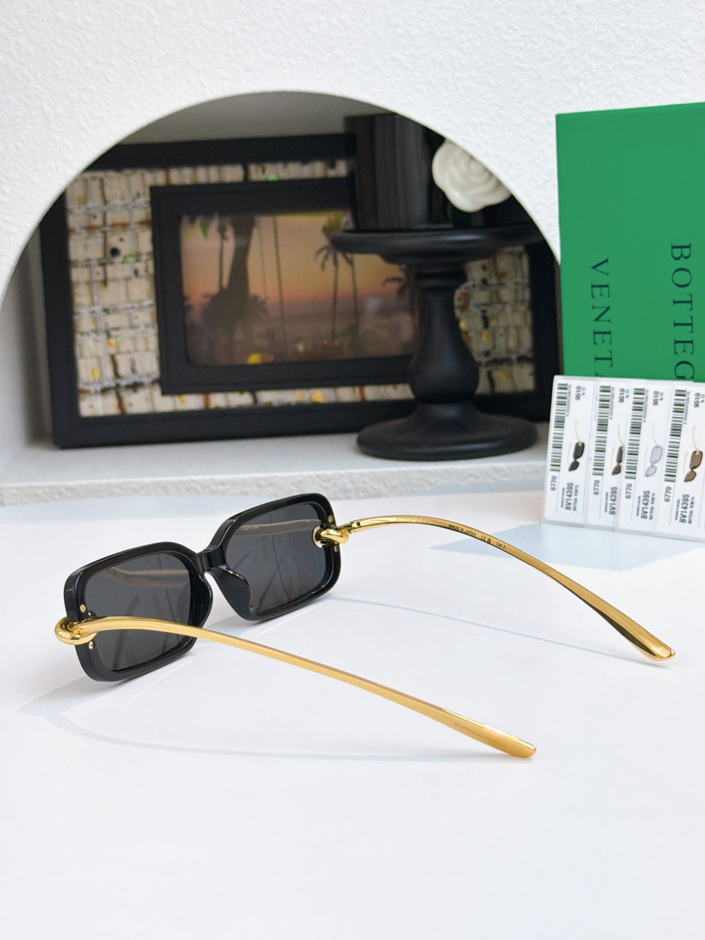 Glasses with dark lenses, black frames, and long gold temples