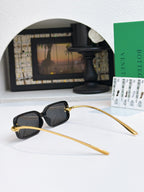 Glasses with dark lenses, black frames, and long gold temples