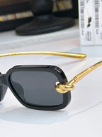 Close-up glasses: black frame with dark lenses and gold temples