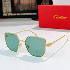 Designer glasses with gold-tone frames and teal tinted lenses, angular silhouette