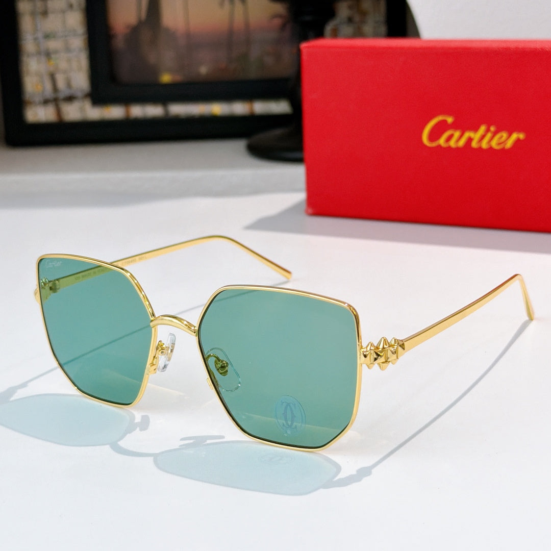 Designer glasses with gold-tone frames and teal tinted lenses, angular silhouette