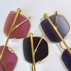 Gold-framed glasses with purple and burgundy tinted lenses, side views
