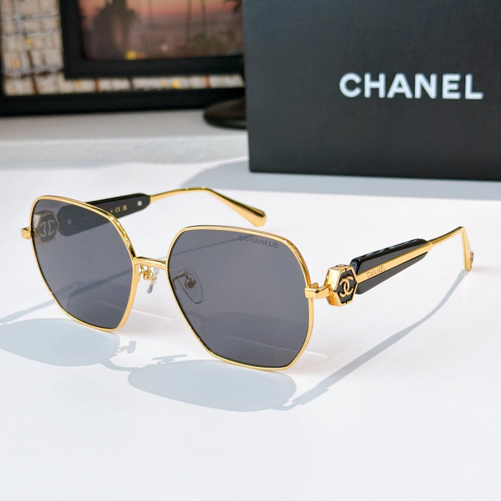 Chanel gold-rim sunglasses with dark tinted lenses and black patterned temples