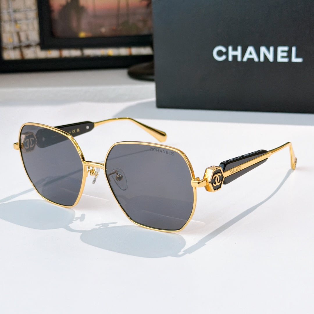Chanel gold-rim sunglasses with dark tinted lenses and black patterned temples