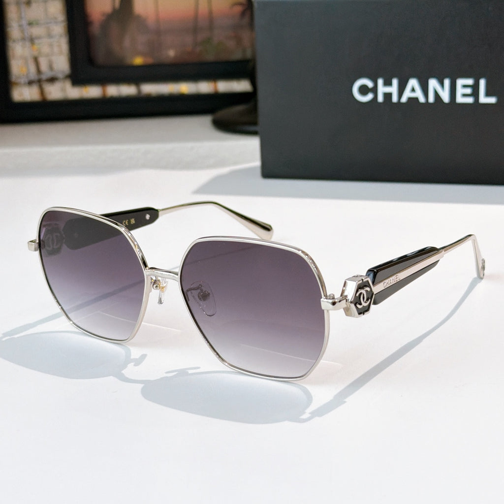 Chanel gold-rim sunglasses with purple tinted lenses and light colored temples
