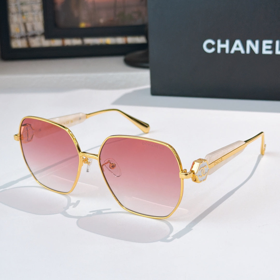 Chanel gold-rim sunglasses with pink tinted lenses and logo hinge detail