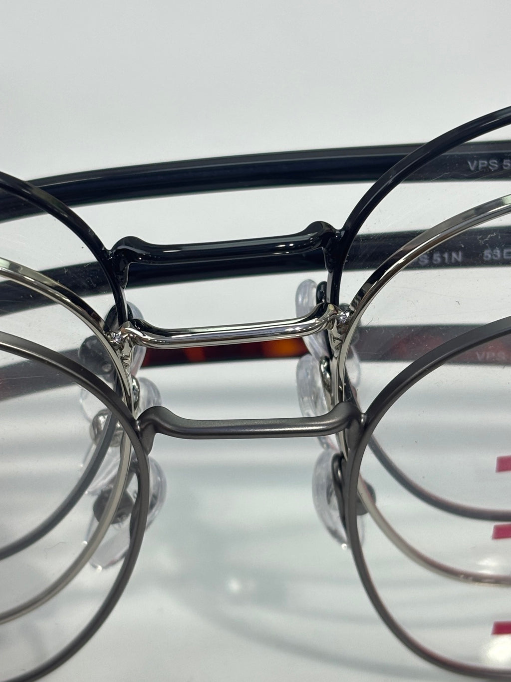 Eyeglasses front view with dark round frames and metal bridge.