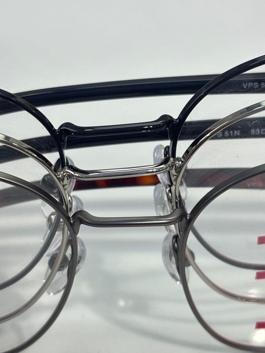 Eyeglasses front view with dark round frames and metal bridge.