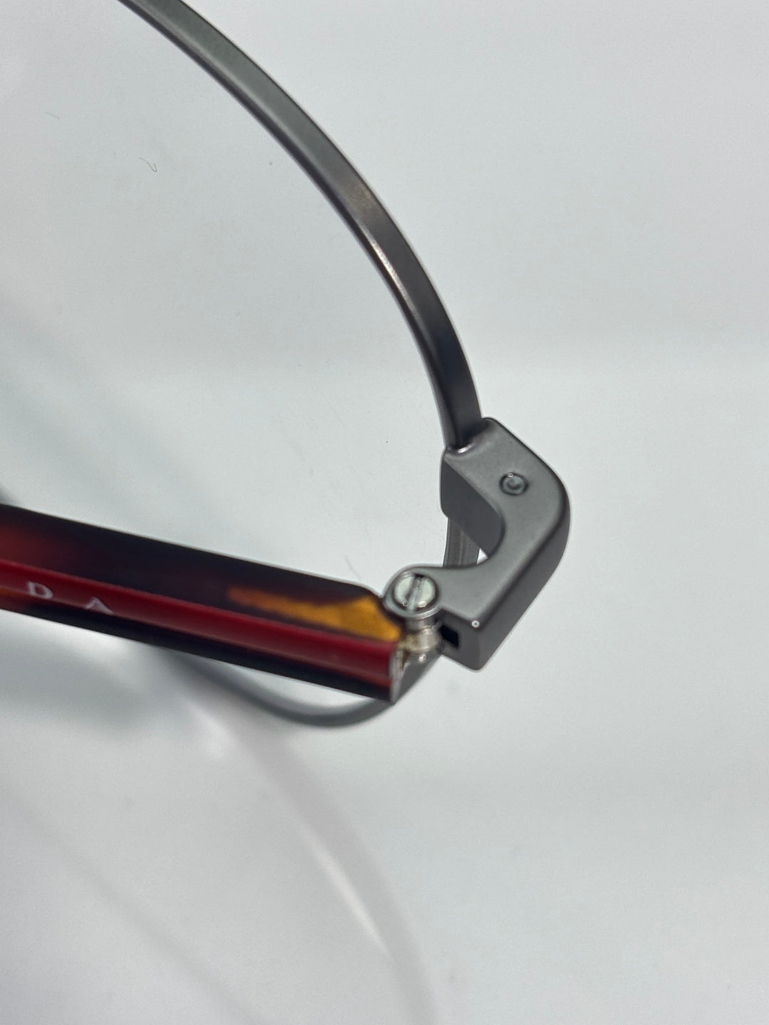 Eyeglasses temple tip with dark frame and red-brown accent on arm.