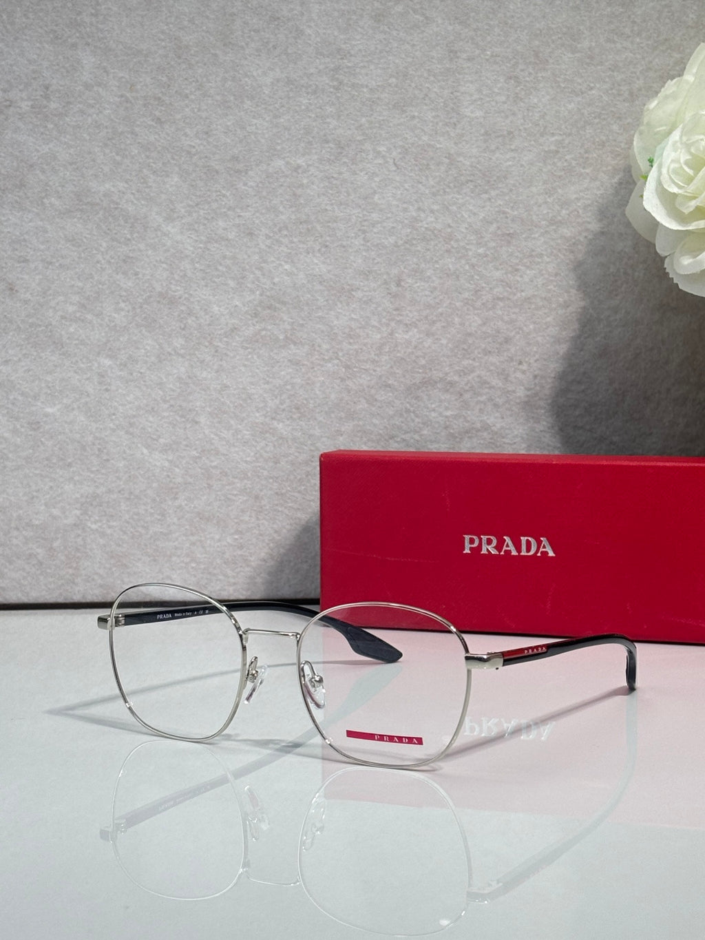 Eyeglasses with dark rectangular frames and clear lenses, side angle.