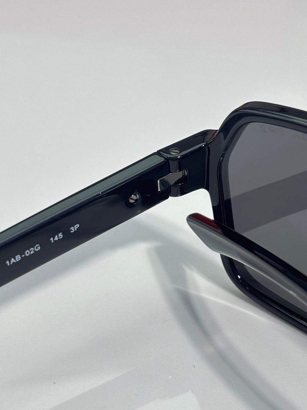 Prada black sunglasses arm with engraved size markings and hinge joint