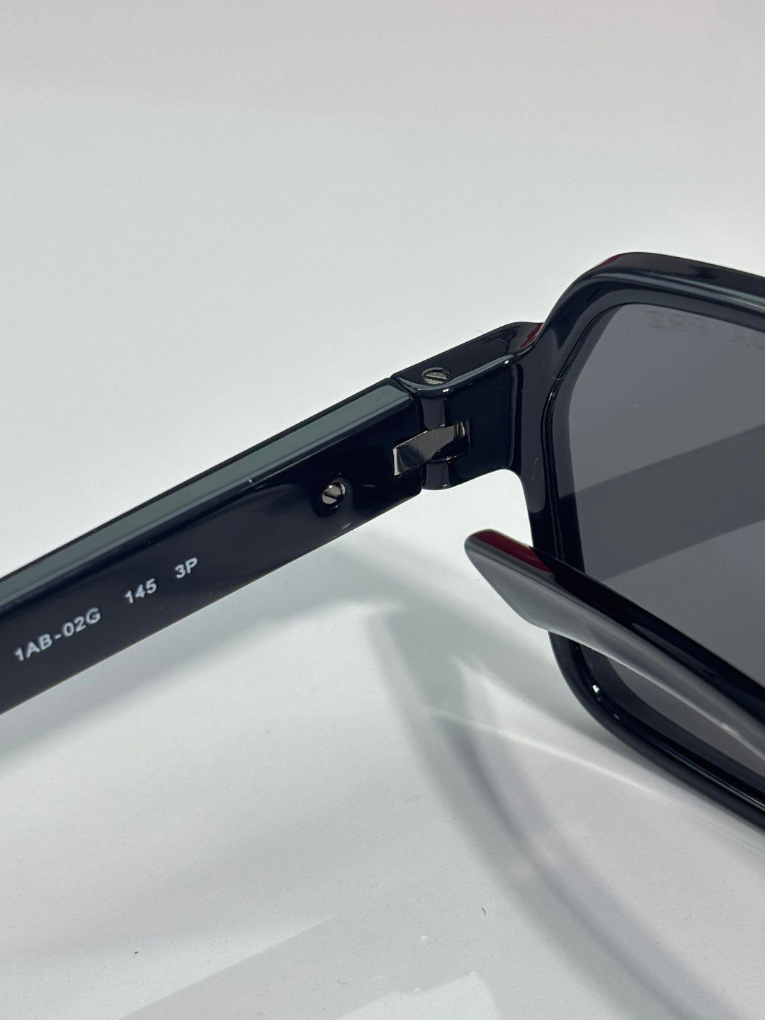 Prada black sunglasses arm with engraved size markings and hinge joint