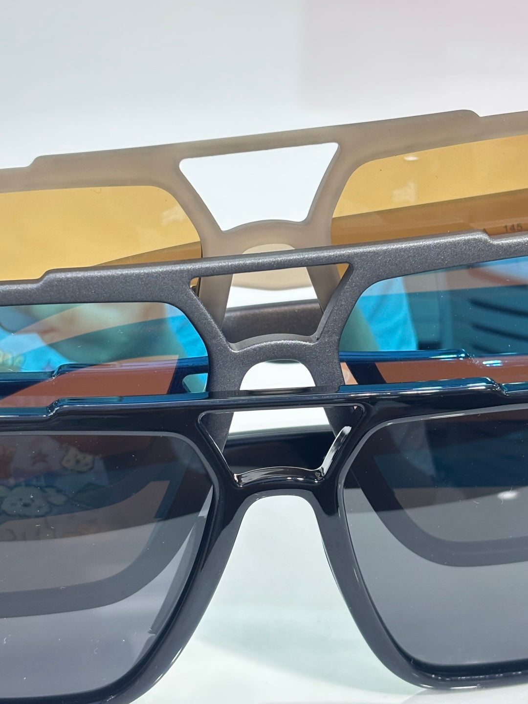 Prada dark sunglasses bridge with yellow-brown frame insert and blue lenses