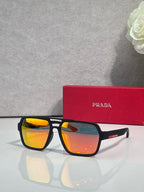 Prada black square sunglasses with orange mirrored lenses, with red Prada case behind