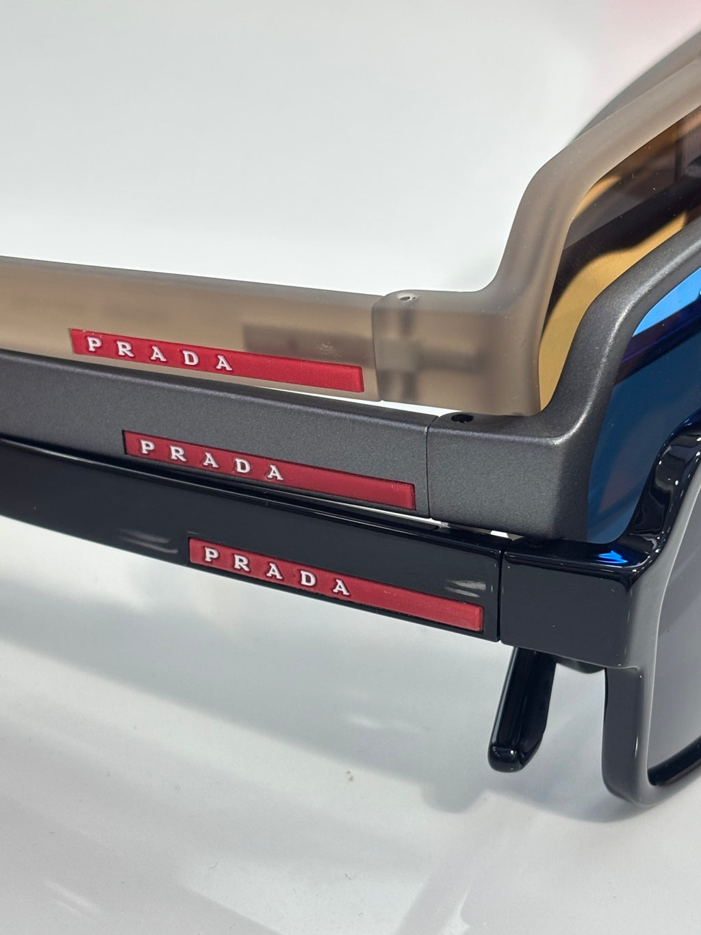 Prada sunglasses temple with red PRADA logo stripe and translucent beige frame