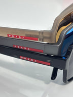 Prada sunglasses temple with red PRADA logo stripe and translucent beige frame
