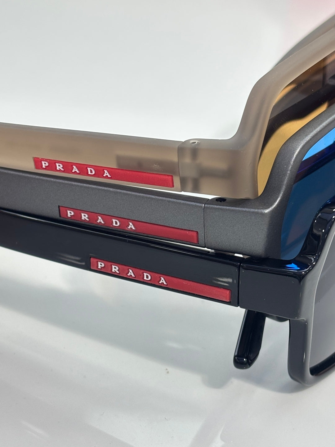 Prada sunglasses temple with red PRADA logo stripe and translucent beige frame