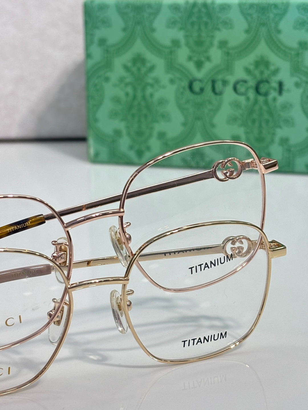 Gucci titanium eyeglasses with gold-tone metal and round GG logo detail, clear lenses
