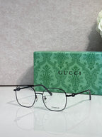 Gucci titanium eyeglasses with black metal frame and clear lenses, logo on front