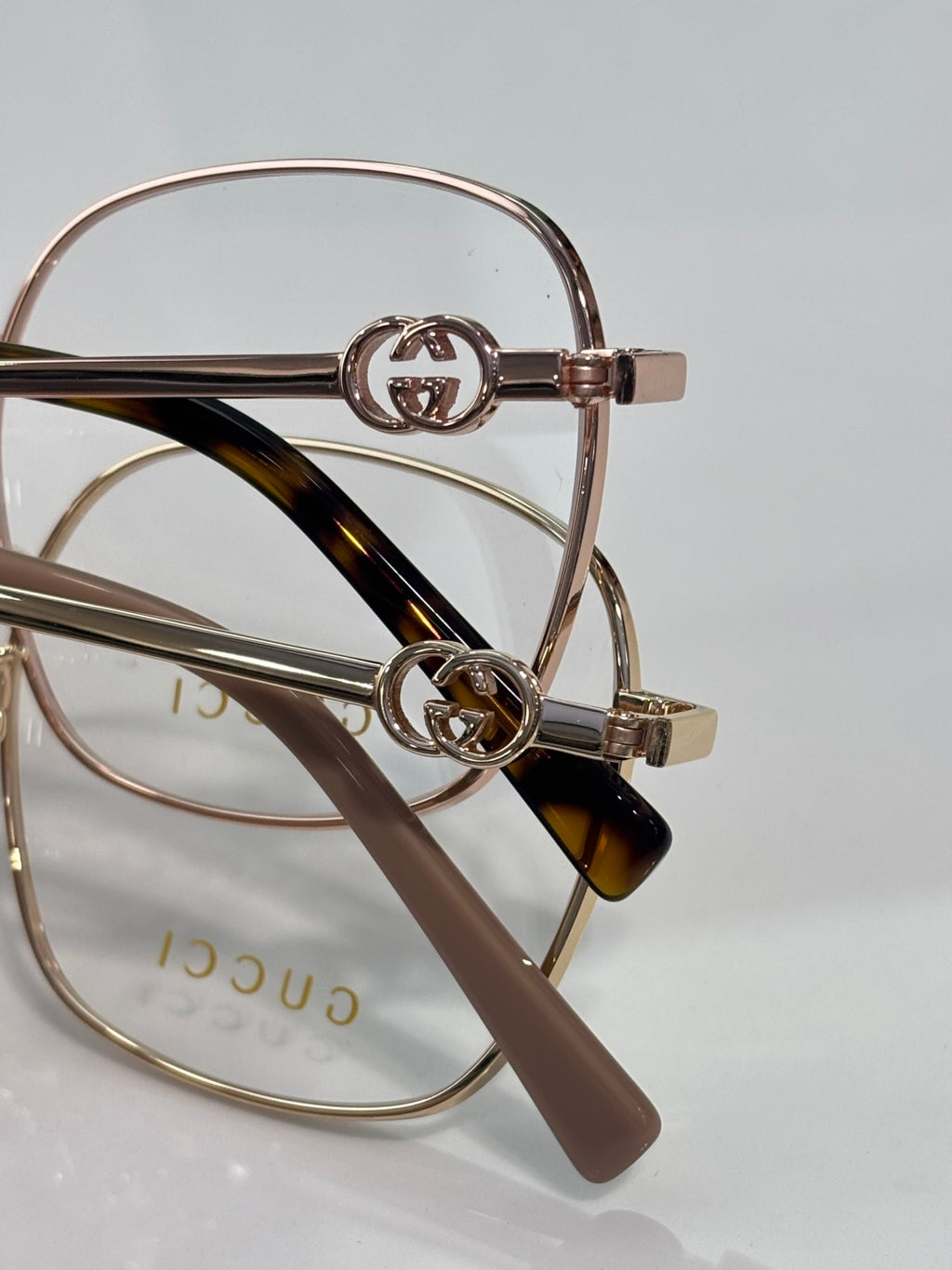 Gucci eyeglasses with GG logo emblem and gold-tone frame, tortoise temple tips