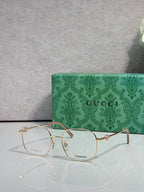 Gucci titanium eyeglasses with gold metal frame and clear lenses, thin rim design