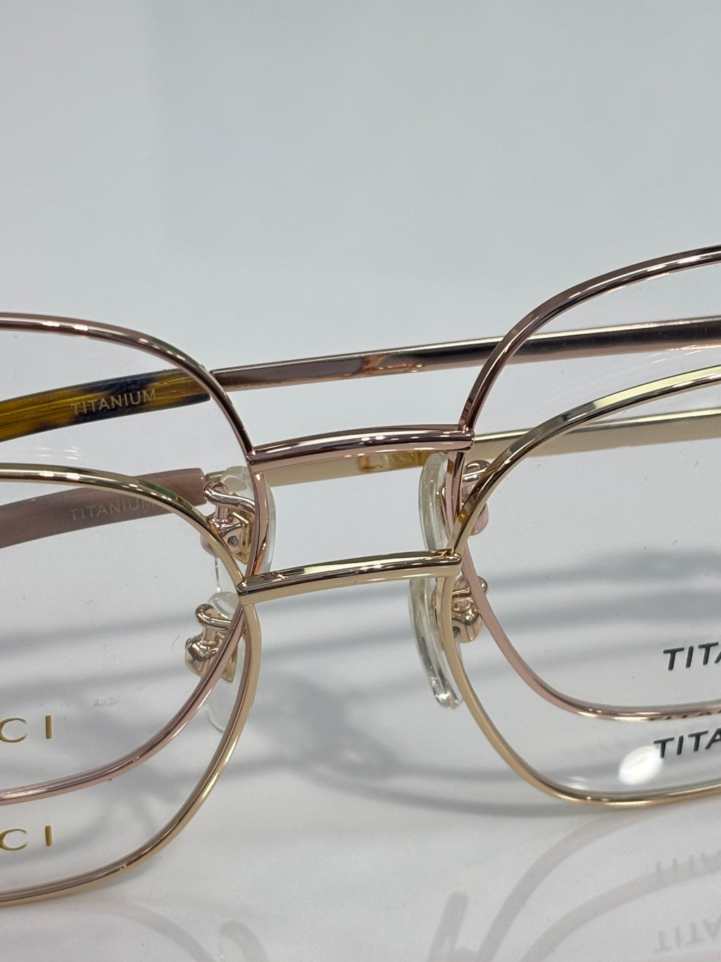 Gucci titanium eyeglasses frame close-up with gold-tone metal and engraved branding