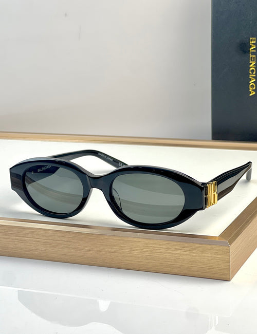 Black oval sunglasses with dark lenses and gold-tone detail on the temple