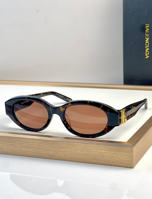 Dark tortoise oval sunglasses with brown lenses and gold-tone temple detail