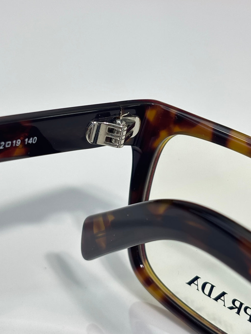 Prada acetate eyeglasses with dark and amber tortoise temple and clear lens