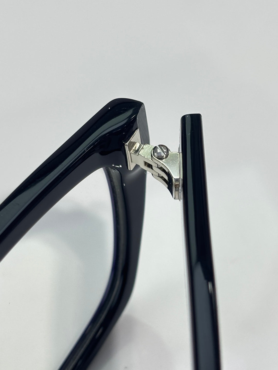 Prada eyeglass hinge detail on dark blue frame with metal hardware