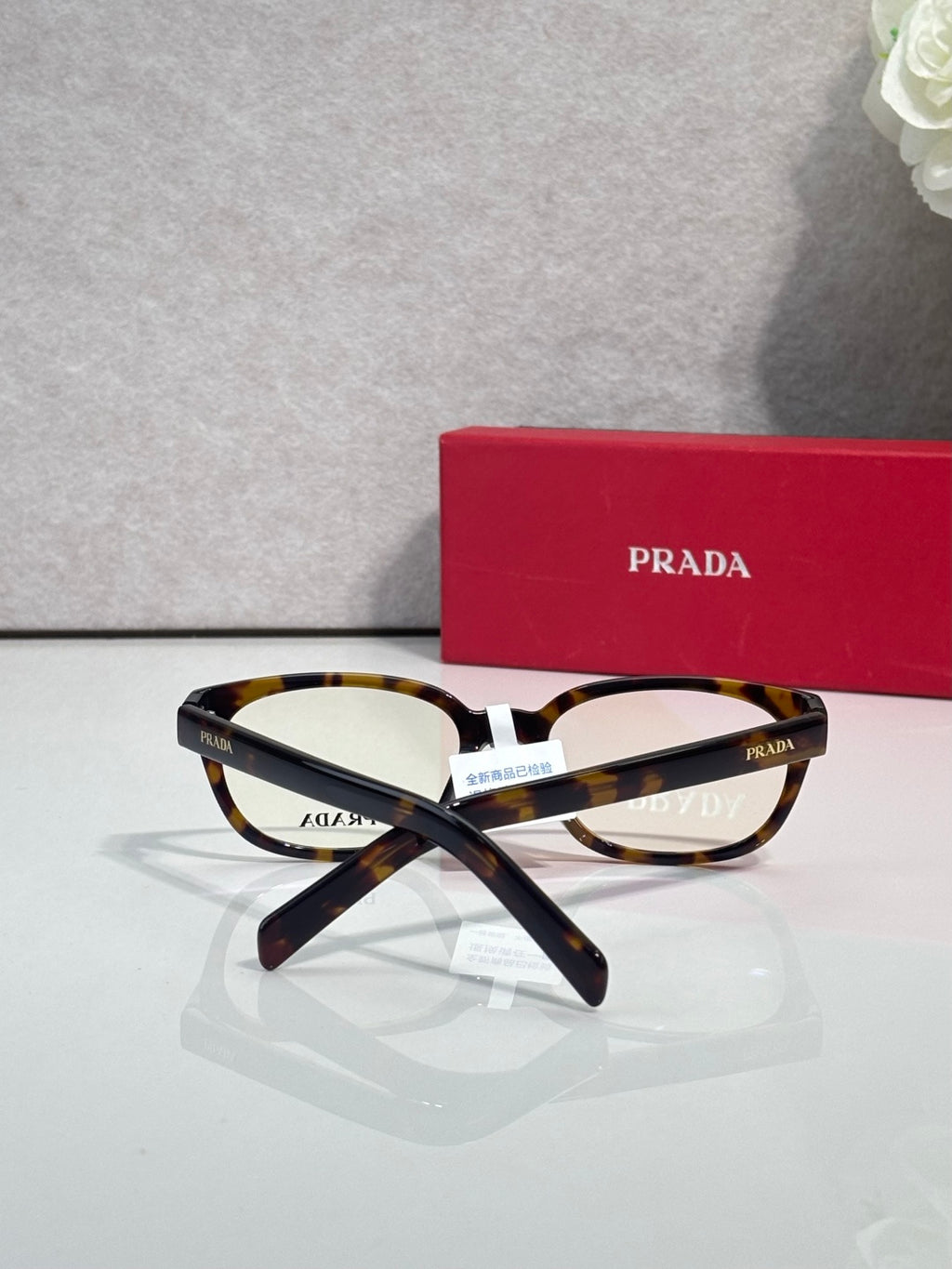 Prada glasses with tortoise-and-black marbled frame and clear lenses, front view.