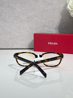 Prada glasses with tortoise-and-black marbled frame and clear lenses, front view.