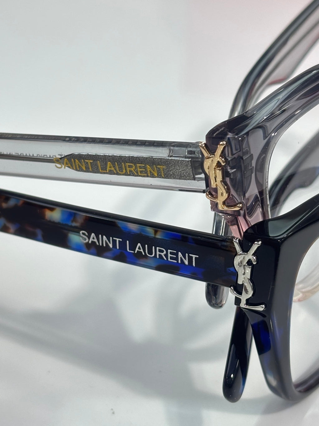Blue patterned eyeglasses with SAINT LAURENT logo on temples and gold emblem