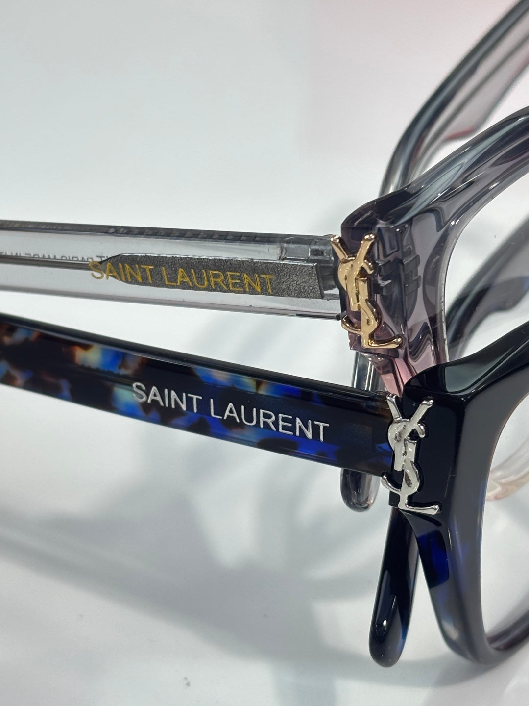 Blue patterned eyeglasses with SAINT LAURENT logo on temples and gold emblem