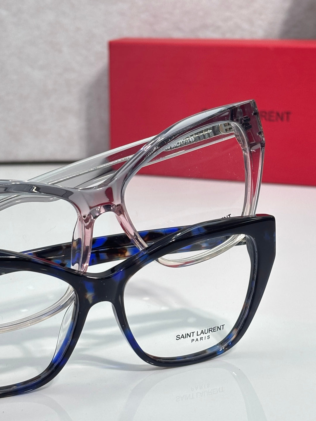 Clear and blue eyeglasses with SAINT LAURENT logo on lens frame