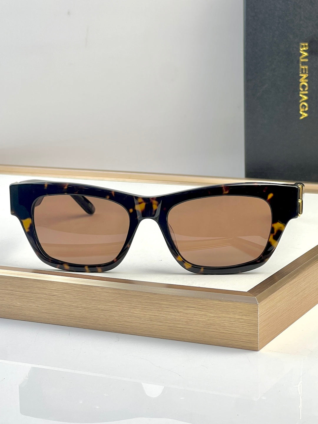 Dark acetate sunglasses with warm gradient lenses and gold-tone temple detail.