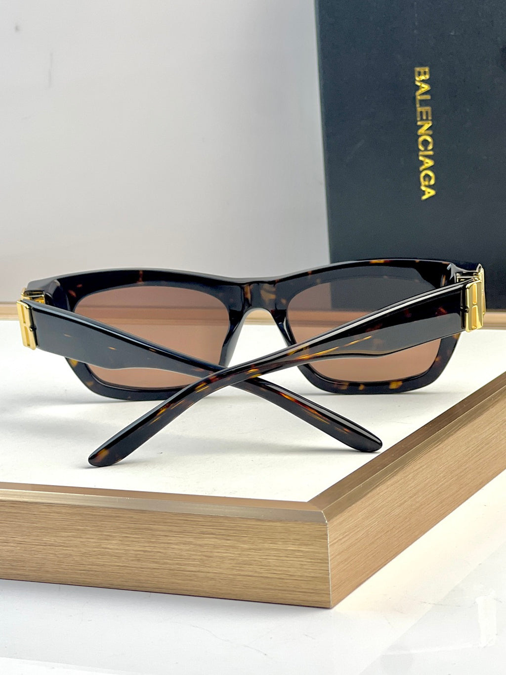 Black and tortoise acetate sunglasses with mirrored lenses and gold-tone temple tips.