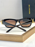 Black and tortoise acetate sunglasses with mirrored lenses and gold-tone temple tips.
