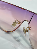 Louis Vuitton sunglasses close-up of purple lens edge and gold-tone hinge