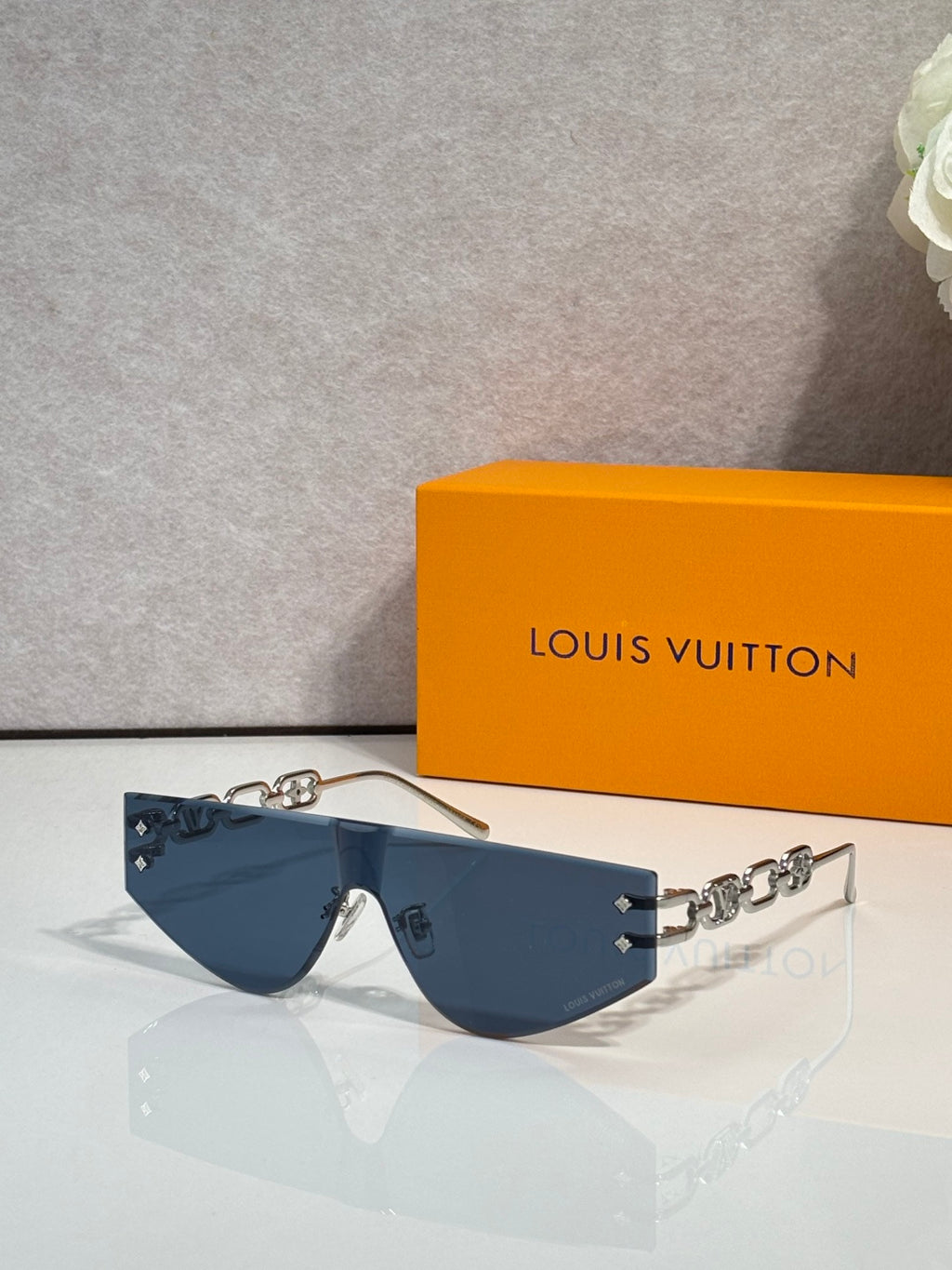 Louis Vuitton sunglasses with dark blue tinted lenses and silver-tone chain temples