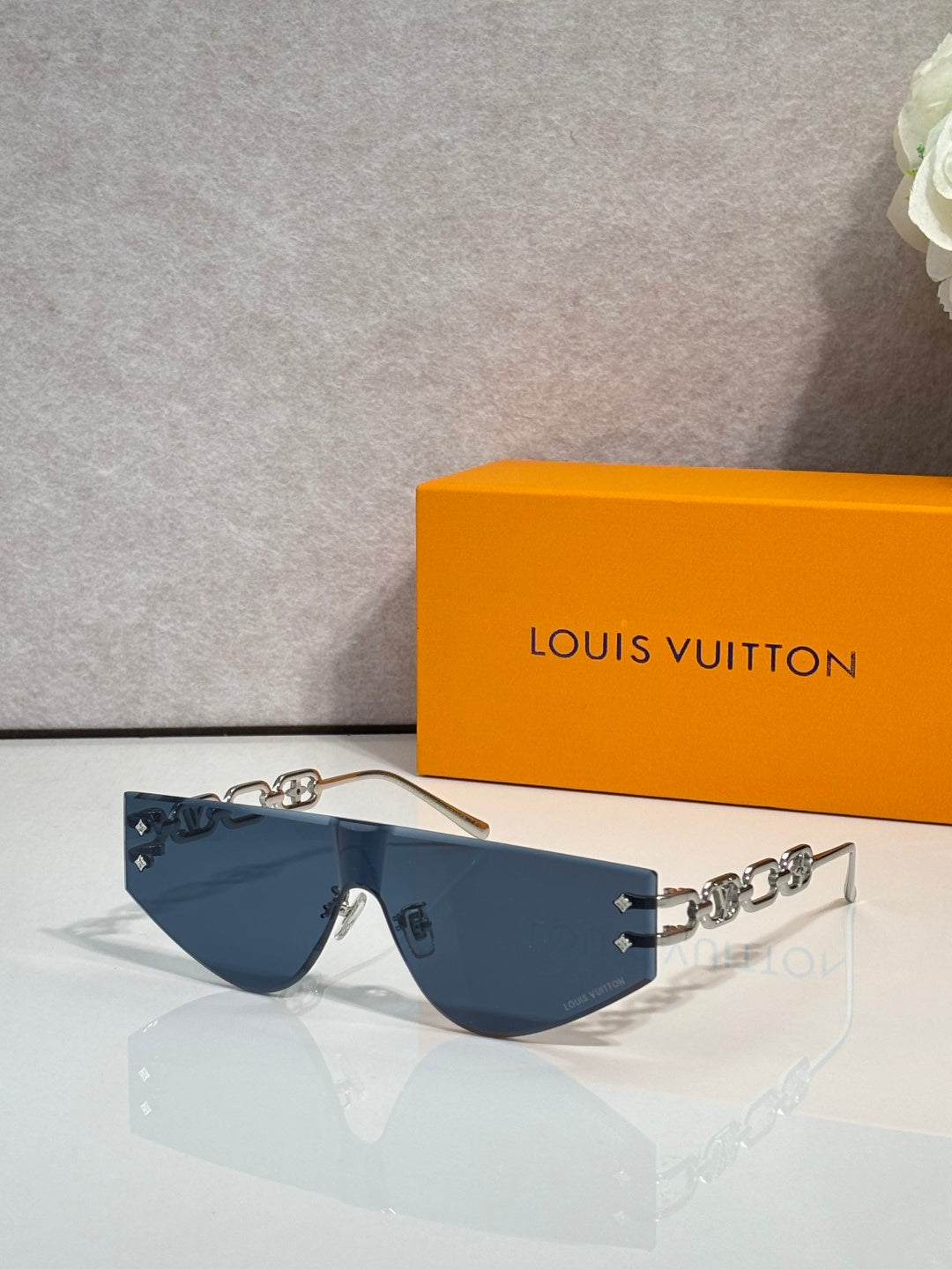 Louis Vuitton sunglasses with dark blue tinted lenses and silver-tone chain temples