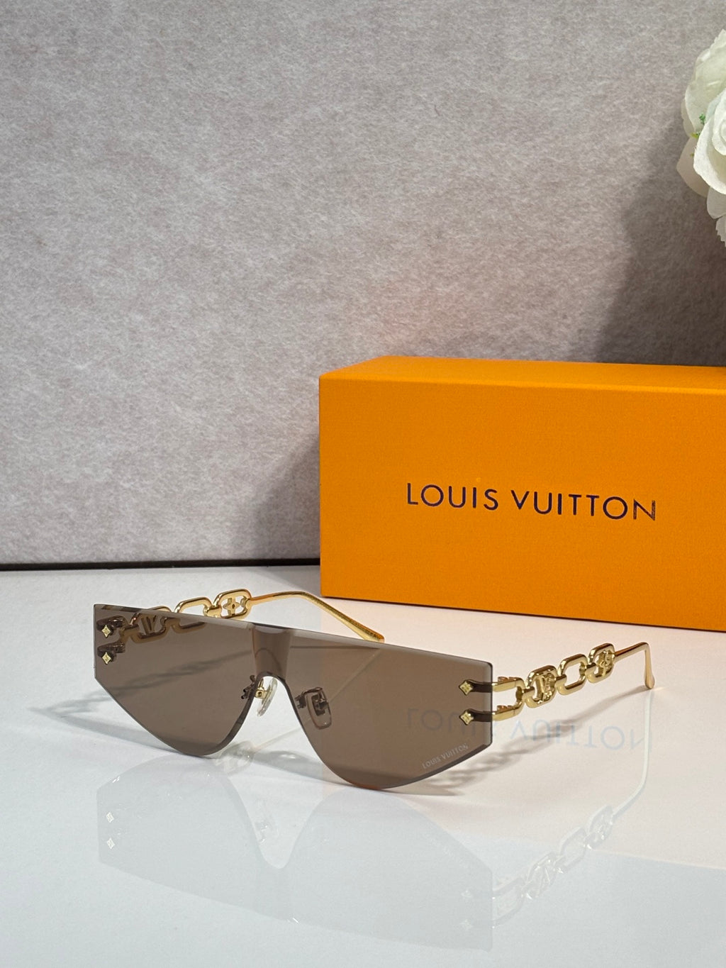 Louis Vuitton sunglasses with brown tinted lenses and gold-tone chain temples
