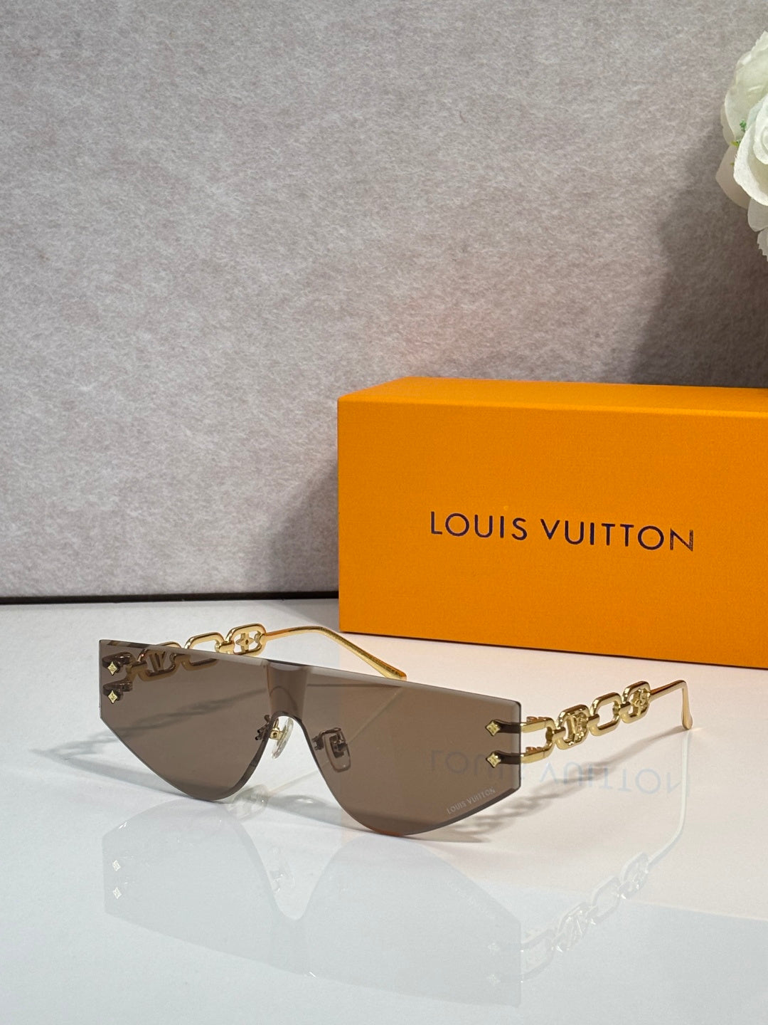 Louis Vuitton sunglasses with brown tinted lenses and gold-tone chain temples