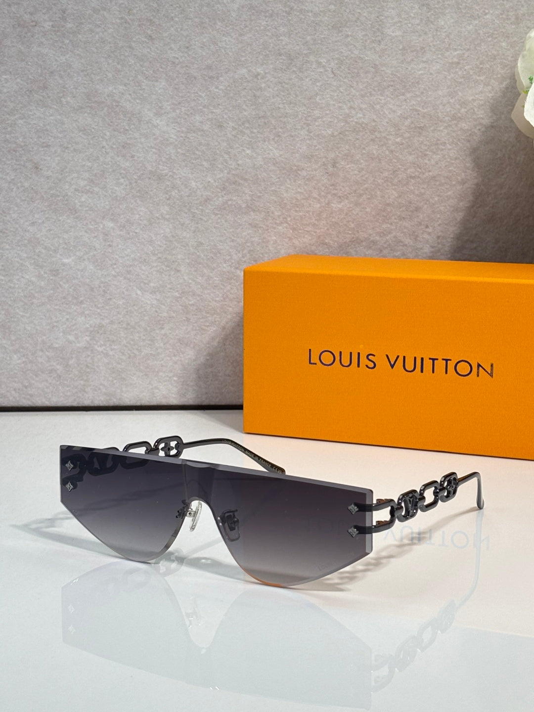 Louis Vuitton sunglasses with dark tinted lenses and silver-tone chain temples